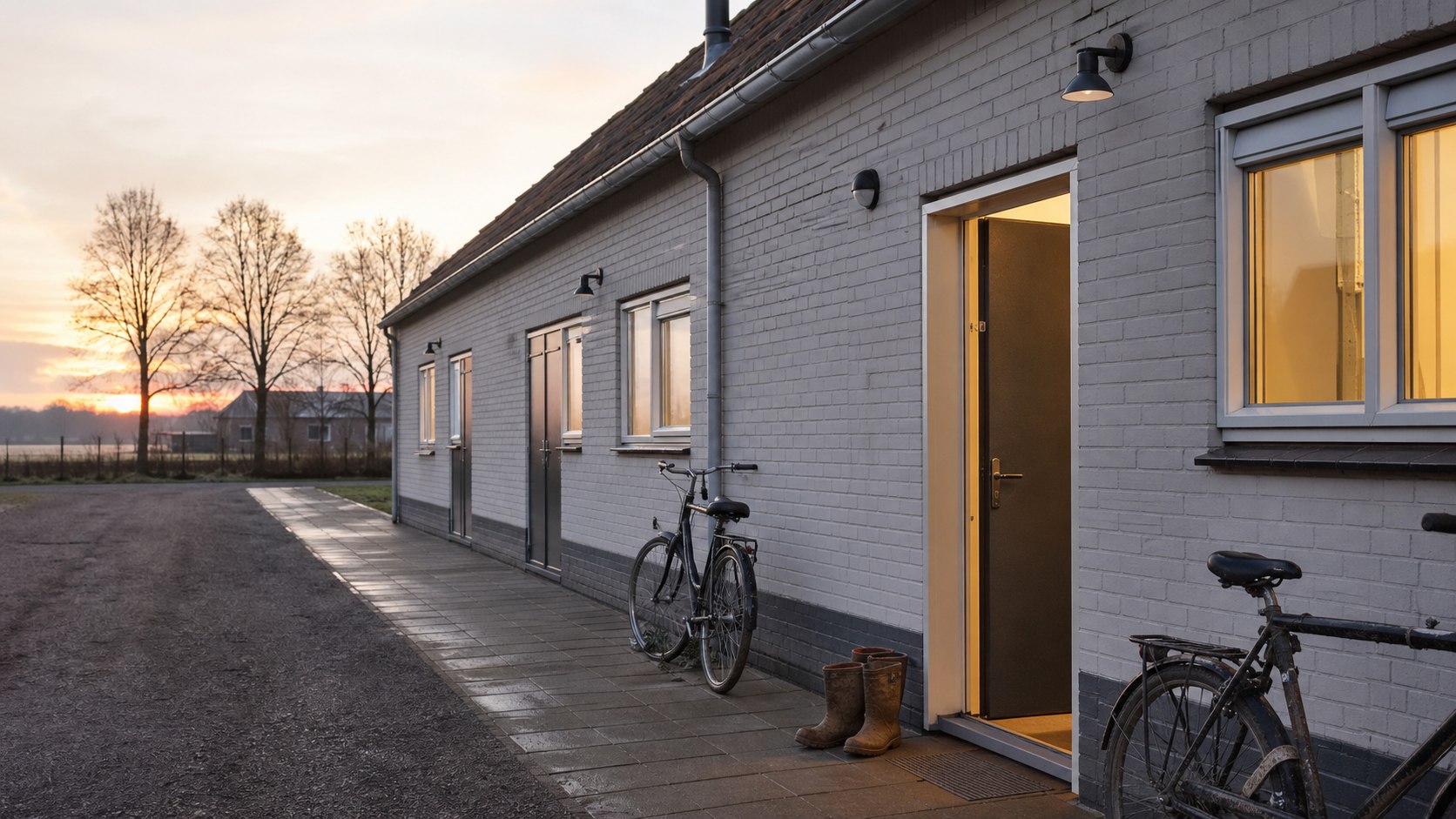 Nette huisvesting voor arbeidsmigranten met fietsen en werkschoenen bij de entree